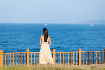 Wall Mural - Asian woman wear dress and look at the sea