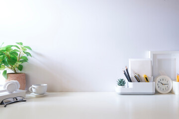Wall Mural - Minimal workspace with book, coffee cup and pencil holder on white table. Copy space for your advertising text.