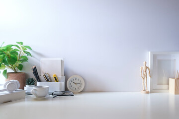 Wall Mural - Minimal workspace with book, coffee cup and pencil holder on white table. Copy space for your advertising text.