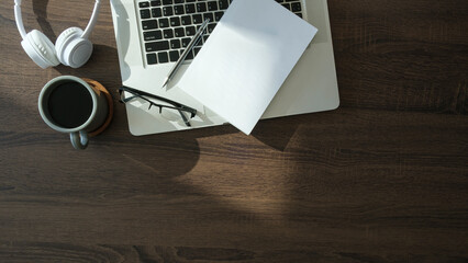 Wall Mural - Flat lay laptop computer, coffee cup and stationery on table with copy space.