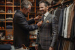 Tailor putting the finishing touches on a male customer's suit.