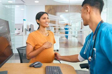 Wall Mural - Male Nurse Or Doctor Wearing Scrubs Examining Pregnant Woman In Hospital Obstetrics Clinic