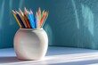 a group of colored pencils in a white vase