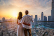 © moofushi - A hugging couple enjoys the beautiful sunset behind the skyline of Downtown Dubai, UAE