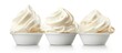 Three cups filled with fluffy whipped cream arranged neatly on a clean white background. The whipped cream is piled high, creating a visually appealing texture and contrast against the plain backdrop.