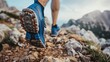 Bottom of running sneaker shoe sole on hard rocky terrain on mountain path during ultra trail marathon race. Strong fit healthy athletic man, trained legs during workout outdoors