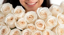 a close up of a person holding a bunch of flowers in front of a woman's face with a smile on her face.