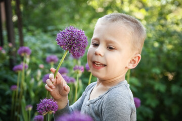 A Happy child with flowers sniffing in the park on nature travel