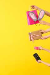 Poster - Women with shopping bag, gift, credit card and payment terminal on yellow background. Easter Sale