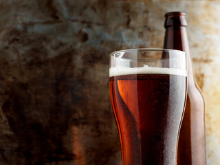 Wall Mural - glass of amber lager beer on an iron background, copy space