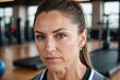 Close-up portrait, seasoned athlete, brown hair, light-skinned, deep wrinkles, piercing gaze, nose piercing, sports clothing, softly blurred background of a sports gym