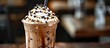 A tall glass filled with iced coffee topped with a generous swirl of whipped cream and sprinkled with chocolate bits. The cold beverage looks refreshing and indulgent, perfect for a hot day.