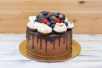 Wall Mural - Chocolate birthday cake with chocolate ganache drip icing, meringue clouds and fresh berries