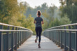 Back view of a female runner in sportswear on a pedestrian bridge, illustrating a commitment to fitness amidst a natural morning setting.