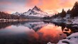 Panoramic view of the snow-capped mountain peaks reflected in the lake at sunrise
