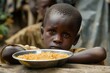 An undernourished boy gazes longingly at a meager meal. underscoring the widespread issue of food scarcity in impoverished regions 