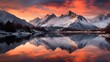 Panoramic view of snow capped mountain peaks reflected in lake at sunset