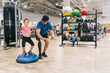 © Daniel Gonzalez/Stocksy - Girl exercising on bosu ball with disabled father