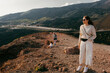 © Jimena Roquero/Stocksy - Woman on top of mountain in the wind admiring views