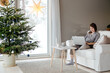 © Sergey Narevskih/Stocksy - Woman working on laptop at Christmas holiday at home