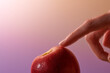 © Marc Tran/Stocksy - Index finger touch fresh red apple in isolated background