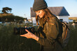 © Christine La/Stocksy - Woman Using Camera Taking Photos Outside at Golden Hour