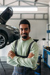 © Studio Firma/Stocksy - Mechanic Standing in Car Workshop