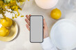 © Artem Podrez/Stocksy - Phone mockup with blank screen on summer dinner table background.