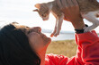 © Luis Herrera/Stocksy - woman holding her cat bonding outdoors