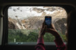 © Luis Herrera/Stocksy - Woman Capturing Memories of Vacation Road Trip with Smartphone