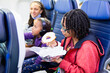 © Anya Brewley Schultheiss/Stocksy - Teen sitting on a plane eating a bage.l