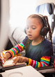 © Anya Brewley Schultheiss/Stocksy - Child with long pigtails colouring while she is on an airplane flight