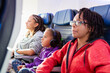 © Anya Brewley Schultheiss/Stocksy - A child and teenagers watching an inflight movie.