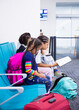 © Anya Brewley Schultheiss/Stocksy - Children reading at an airport while waiting  to board a flight