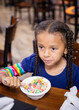 © Anya Brewley Schultheiss/Stocksy - Child with long pigtails eating cereal