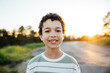 © Rob and Julia Campbell/Stocksy - Portrait of cute curly haired boy having fun outside.