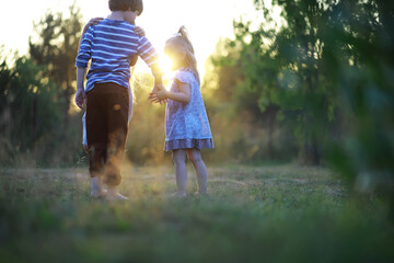 Wall Mural - Children walk in the summer in nature. Child on a sunny spring morning in the park. Traveling with children.