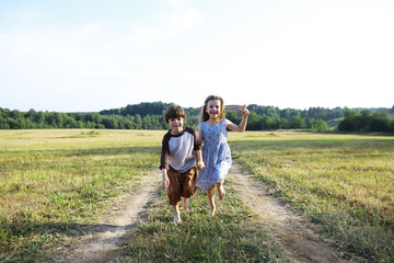 Wall Mural - Children walk in the summer in nature. Child on a sunny spring morning in the park. Traveling with children.