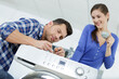 woman looking at repairman repairing dishwasher in kitchen