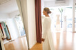 © Lupe Rodríguez/Stocksy - mature woman trying on her wedding dress