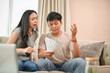 © bongkarn - Unhappy Asian spouses are arguing about unexpected high household bills and credit card invoices.