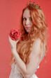 Portrait of a red-haired princess with an artificial flower in her hand