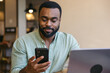 © Pedro Merino/Stocksy - A man working with a laptop and smartphone in a cafe.