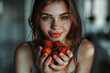 young woman is holding ripe fresh homegrown strawberries in her hands