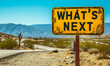 A yellow road sign stands under a clear sky, asking WHAT'S NEXT? against the backdrop of a winding desert road, symbolizing uncertainty and future possibilities