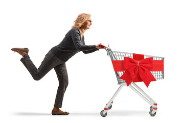 Sticker - Full length profile shot of a mature woman running with a shopping cart tied with a red ribbon