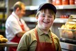 A happy down syndrome boy working in a fastfood restaurant.