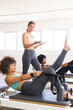 © Wavebreak Media - Young Caucasian woman instructs biracial women at a gym on pilates reformers