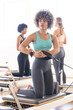 © Wavebreak Media - Young biracial woman exercises on a Pilates reformer at a fitness studio