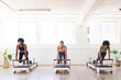© Wavebreak Media - Three women engage in a Pilates workout at a bright studio on reformers